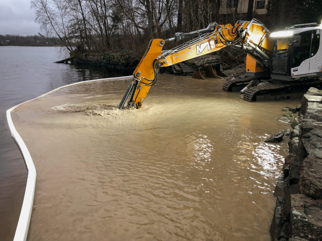 Ground & Water Consulting gräver med en grävmaskin i en sjö